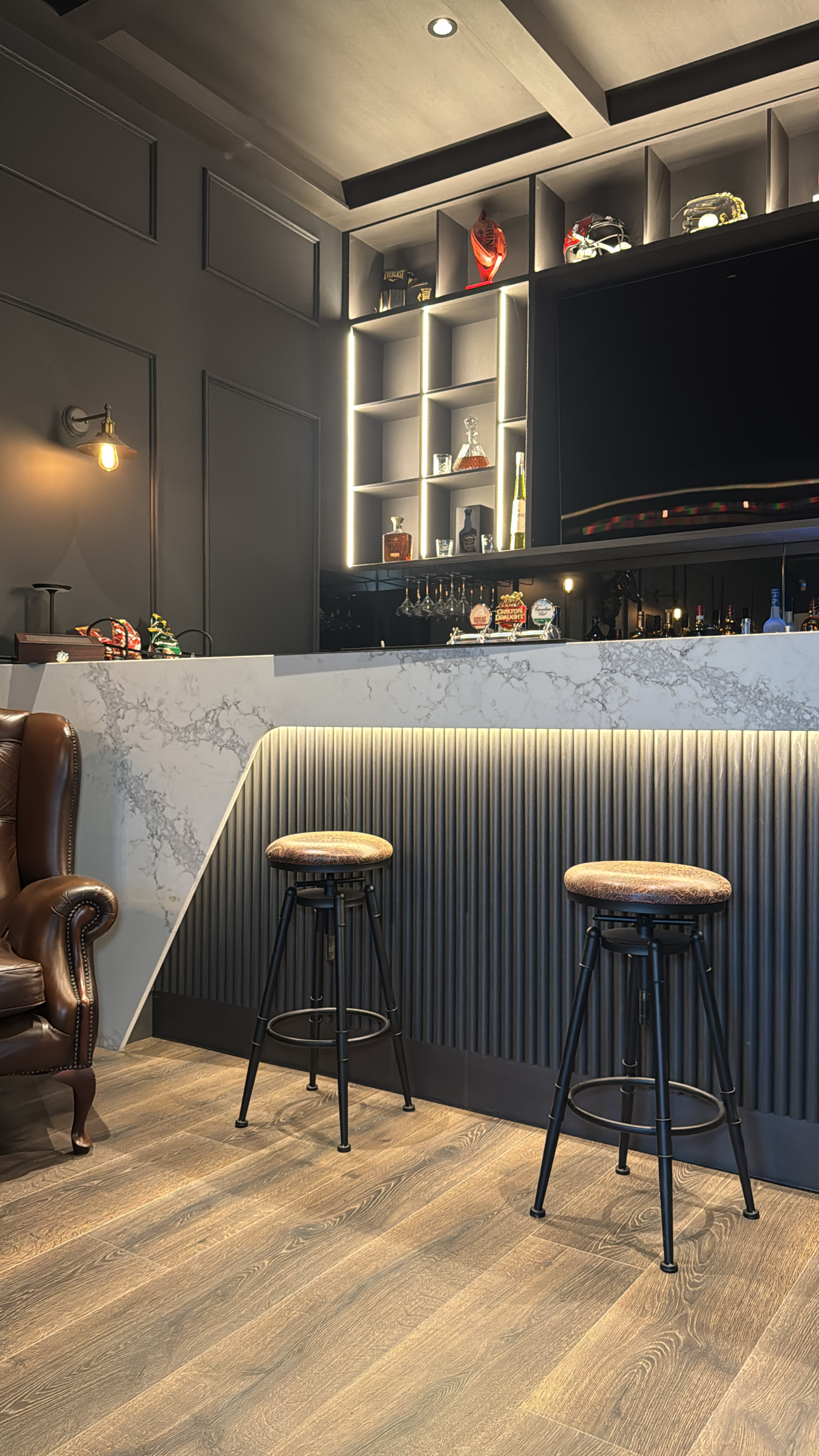 Custom home bar cabinetry with stone and LED lighting